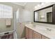 Bright bathroom featuring double sinks, a shower, and a decorative mirror at 2746 Windsorgate Ln, Orlando, FL 32828