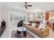 Open living space features a plush sofa, large windows, and a glass coffee table, perfect for relaxing at 2746 Windsorgate Ln, Orlando, FL 32828