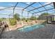 A lovely screened-in pool features a rock waterfall and stone surround, perfect for outdoor relaxation at 2746 Windsorgate Ln, Orlando, FL 32828