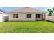 View of the home's rear exterior showcasing well-maintained lawn and fenced yard providing privacy and security at 296 Inman Blvd, Winter Haven, FL 33881
