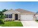 Charming single-story home with a well-manicured lawn, lovely landscaping, and an attached two-car garage at 296 Inman Blvd, Winter Haven, FL 33881