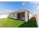 Exterior view of the home showing the screened lanai, fenced backyard, and well-maintained lawn at 296 Inman Blvd, Winter Haven, FL 33881