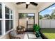 Relaxing outdoor patio with two chairs and table, plants, a ceiling fan, and view of the backyard at 296 Inman Blvd, Winter Haven, FL 33881