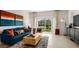Bright living room featuring a stylish sofa, modern decor, and sliding glass doors to the outside at 3060 Skyline Loop, Kissimmee, FL 34758
