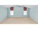 An empty bedroom shows large windows and light blue walls, awaiting its new occupants and décor at 3065 Bridgehampton Ln, Orlando, FL 32812
