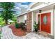 Inviting entrance with brick detail, stone walkway, and a red door, creating a warm welcome at 3065 Bridgehampton Ln, Orlando, FL 32812