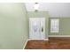 Bright foyer with hardwood floors, featuring an oval-windowed white door and plantation shutters at 3065 Bridgehampton Ln, Orlando, FL 32812
