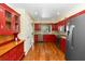 Functional kitchen features stainless steel appliances, granite countertops, and red cabinetry at 3065 Bridgehampton Ln, Orlando, FL 32812