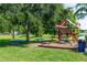 Community playground with swing set, picnic tables, and a lake view at 3065 Bridgehampton Ln, Orlando, FL 32812