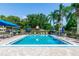 Relaxing community pool area with lounge chairs, umbrellas, and lush landscaping for a resort-like experience at 3065 Bridgehampton Ln, Orlando, FL 32812