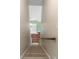 Carpeted stairs lead to a landing featuring a light green wall and white entry door with oval window at 3065 Bridgehampton Ln, Orlando, FL 32812