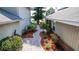 Charming brick walkway between houses with lush landscaping and a tranquil garden at 3065 Bridgehampton Ln, Orlando, FL 32812