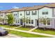 Street view of modern townhomes with landscaped lawns, sidewalks, and visitor parking at 3335 Azolla St, Orlando, FL 32808