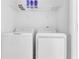 Modern laundry area with front-load washer and dryer, plus overhead shelving for supplies at 3335 Azolla St, Orlando, FL 32808