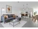 Modern living room with stylish gray sofa and a view of the open-concept kitchen at 3335 Azolla St, Orlando, FL 32808