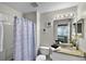 Bright bathroom with a shower/tub combo, granite vanity, and a mirror with decorative lights at 339 Holborn Loop, Davenport, FL 33897