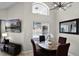 A bright dining area with a view of the pool, a modern light fixture, and neutral decor at 339 Holborn Loop, Davenport, FL 33897