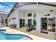 Covered pool patio with outdoor seating, lounge chair, and access to the home at 339 Holborn Loop, Davenport, FL 33897