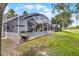 A view of the backyard and screened patio with furniture, perfect for outdoor relaxation at 339 Holborn Loop, Davenport, FL 33897