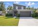 Modern two-story home with dark gray stucco, stone accents, manicured lawn, and large driveway at 3650 Grant Blvd, Orlando, FL 32804