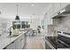 Bright kitchen with white cabinets, a quartz island, and stainless appliances with a dining area at 3650 Grant Blvd, Orlando, FL 32804