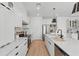 Contemporary white kitchen features stainless steel appliances, an island with seating, and custom cabinetry at 3650 Grant Blvd, Orlando, FL 32804