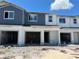 Charming townhome exterior featuring a blue and white color scheme, garage, and unfinished landscaping at 4248 Campsite Loop, Orlando, FL 32824