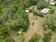 Expansive aerial view of property with a mixture of wooded areas and grass surrounding the buildings at 4802 Anton Ave, Apopka, FL 32712