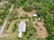 Aerial view of a charming home featuring mature trees and a spacious yard with multiple storage buildings on the property at 4802 Anton Ave, Apopka, FL 32712