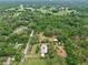 Overhead view displaying residence and storage buildings on a large property surrounded by lush woods at 4802 Anton Ave, Apopka, FL 32712