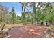 Expansive backyard with brick patio, mature trees, and a charming wooden fence at 4802 Anton Ave, Apopka, FL 32712