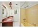 Bright bathroom features a dual sink vanity, vintage bathtub, and a shower with classic tile work, offering comfort at 4802 Anton Ave, Apopka, FL 32712