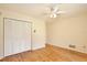 Bedroom featuring hardwood floors, a ceiling fan, and a closet providing ample storage, blending comfort and functionality at 4802 Anton Ave, Apopka, FL 32712