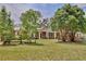Charming brick home featuring a large front yard with mature trees and a rustic wooden fence at 4802 Anton Ave, Apopka, FL 32712