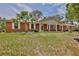 Inviting brick home with a covered porch and classic white columns, set on a lush green lawn at 4802 Anton Ave, Apopka, FL 32712