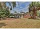 Rear exterior view of home highlighting brick and siding, windows, and lush landscaping at 4802 Anton Ave, Apopka, FL 32712