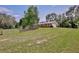 Brick home with a well-maintained lawn, complemented by a charming wooden fence and mature trees at 4802 Anton Ave, Apopka, FL 32712