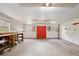 Garage with shelving, pegboard walls, and access to the exterior through vibrant red doors, providing functionality and convenience at 4802 Anton Ave, Apopka, FL 32712