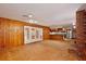 Living room featuring a fireplace, wood walls, ceiling fan, and access to the kitchen at 4802 Anton Ave, Apopka, FL 32712