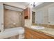 Bathroom featuring a tub with tiled wall, vanity, and large mirror at 4952 Tangerine Ave # 4952, Winter Park, FL 32792
