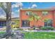 Back exterior view with patio, lush landscaping, and sunny sky at 4952 Tangerine Ave # 4952, Winter Park, FL 32792