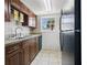 Galley kitchen features wooden cabinets, black appliances, stone countertops and a stainless steel sink at 4952 Tangerine Ave # 4952, Winter Park, FL 32792