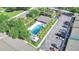 Aerial view of a community pool surrounded by palm trees with lounge chairs and parking area at 4952 Tangerine Ave # 4952, Winter Park, FL 32792