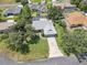 Aerial view of a well-maintained home with a screened pool, mature trees and a long driveway at 5382 Sw 84Th Pl, Ocala, FL 34476