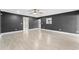 Expansive living area with neutral tones, tile flooring, ceiling fan, and a pass-through window to the kitchen at 540 Diane Cir, Casselberry, FL 32707