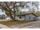 View of the home's side exterior featuring a mature tree with Spanish moss, manicured landscaping, and a well-maintained lawn at 540 Diane Cir, Casselberry, FL 32707