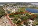 Aerial view of a red-roofed home inside of a defined property line near a pond and a neighborhood at 5671 Cypress Gardens Rd, Winter Haven, FL 33884