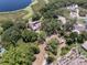Expansive aerial view of a home near a lake and surrounded by lush greenery and trees, offering privacy at 5671 Cypress Gardens Rd, Winter Haven, FL 33884