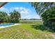 Lush backyard with waterfront view, featuring a pool and spacious lawn at 5671 Cypress Gardens Rd, Winter Haven, FL 33884