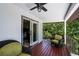 Enjoy the covered balcony with ceiling fan, wood deck and outdoor seating with views of the beautiful surrounding landscape at 5671 Cypress Gardens Rd, Winter Haven, FL 33884